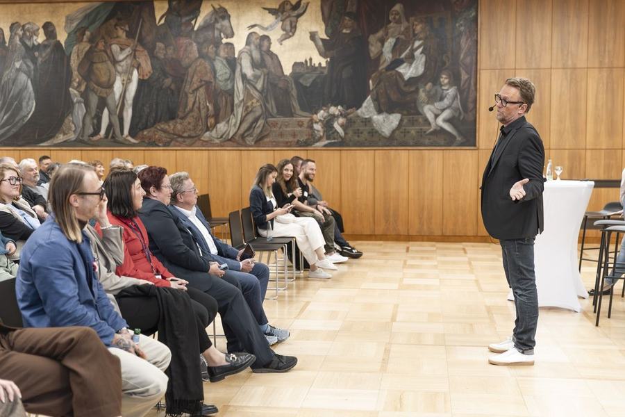 Michael Leibrecht moderiert vor Publikum im historischen Rathaussaal